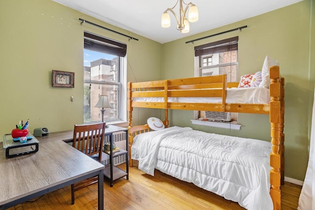 bedroom featuring light wood-style floors and an inviting chandelier