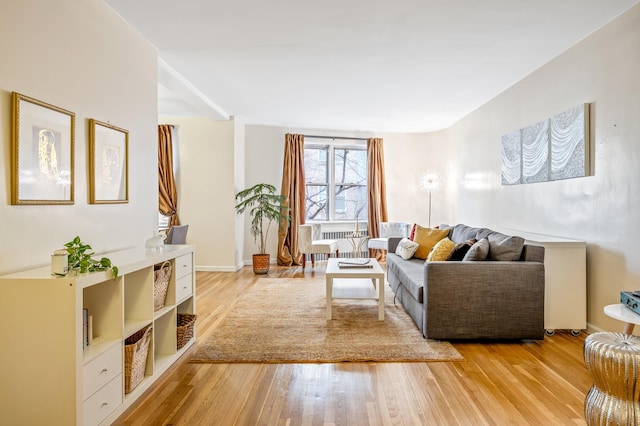 living area with radiator, light wood-style flooring, and baseboards