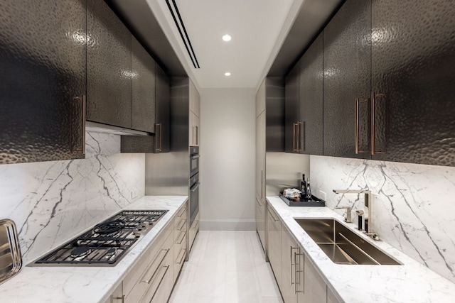 kitchen featuring sink, light stone countertops, stainless steel gas cooktop, and tasteful backsplash