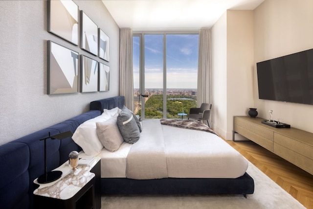 bedroom with light parquet flooring and expansive windows