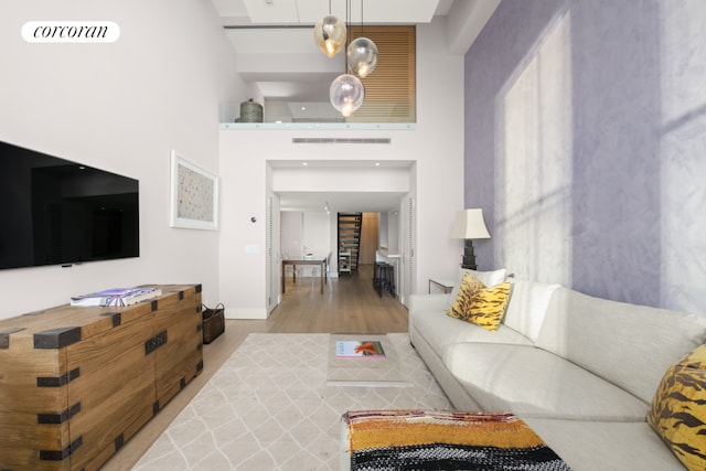 living room with a towering ceiling and hardwood / wood-style floors