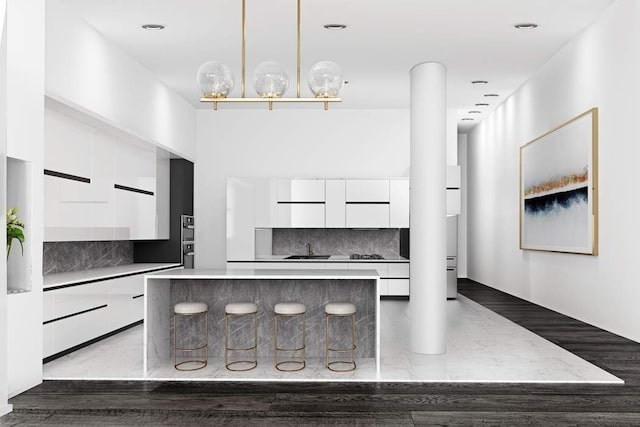 kitchen with hanging light fixtures, tasteful backsplash, a kitchen island, and white cabinets