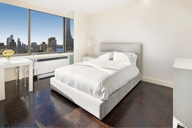 bedroom featuring baseboards and a city view