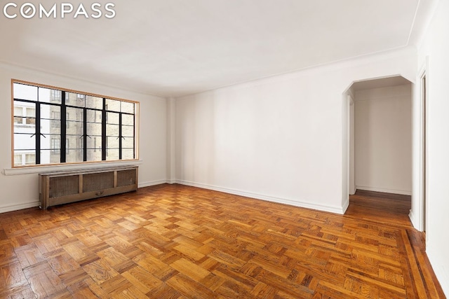 unfurnished room featuring radiator and parquet flooring