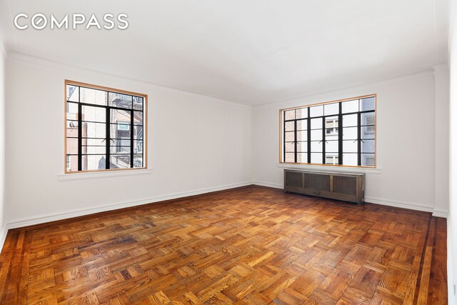 unfurnished room featuring baseboards and arched walkways