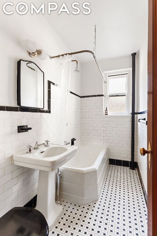 bathroom featuring tile walls and shower / bath combo