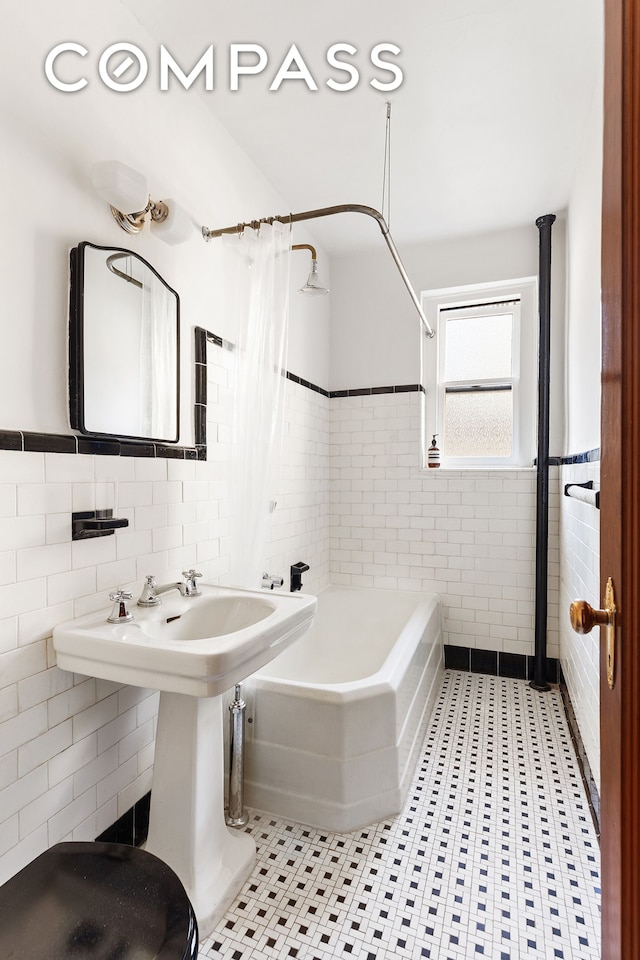 135 E 39th St Unit 5E, New York City, NY 10016 - full bath featuring tile walls, shower / bath combination with curtain, tile patterned floors, and wainscoting
