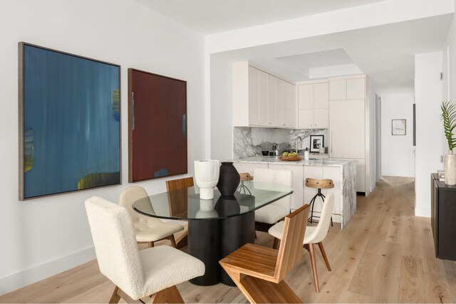 dining area with light wood-style floors and baseboards