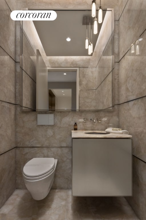 bathroom with vanity, tile walls, and toilet