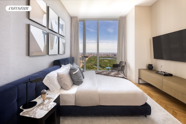 bedroom featuring light parquet flooring and a wall of windows