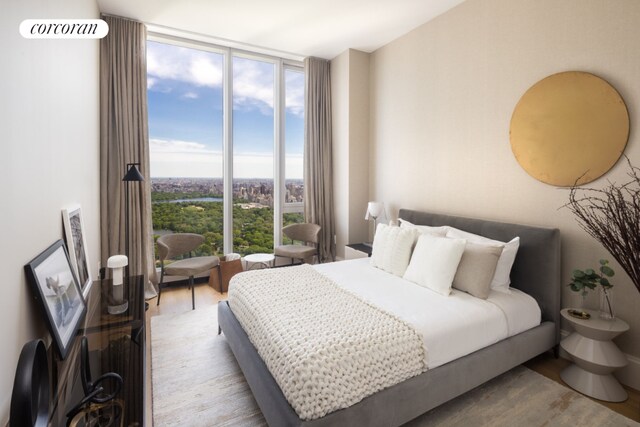 bedroom with a wall of windows and light hardwood / wood-style floors