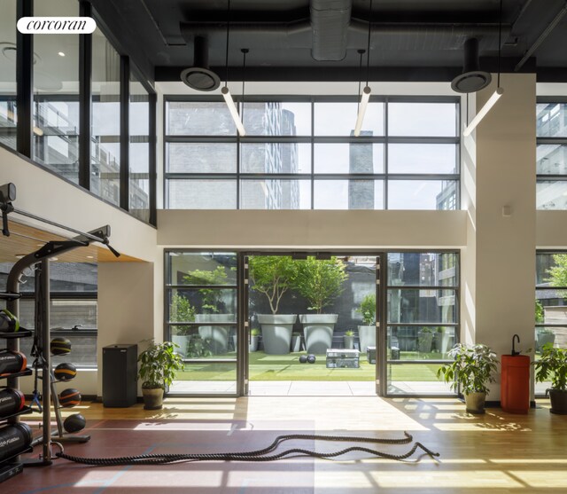 bedroom with floor to ceiling windows and light wood-type flooring