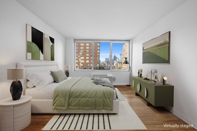 bedroom with wood-type flooring and a wall mounted AC