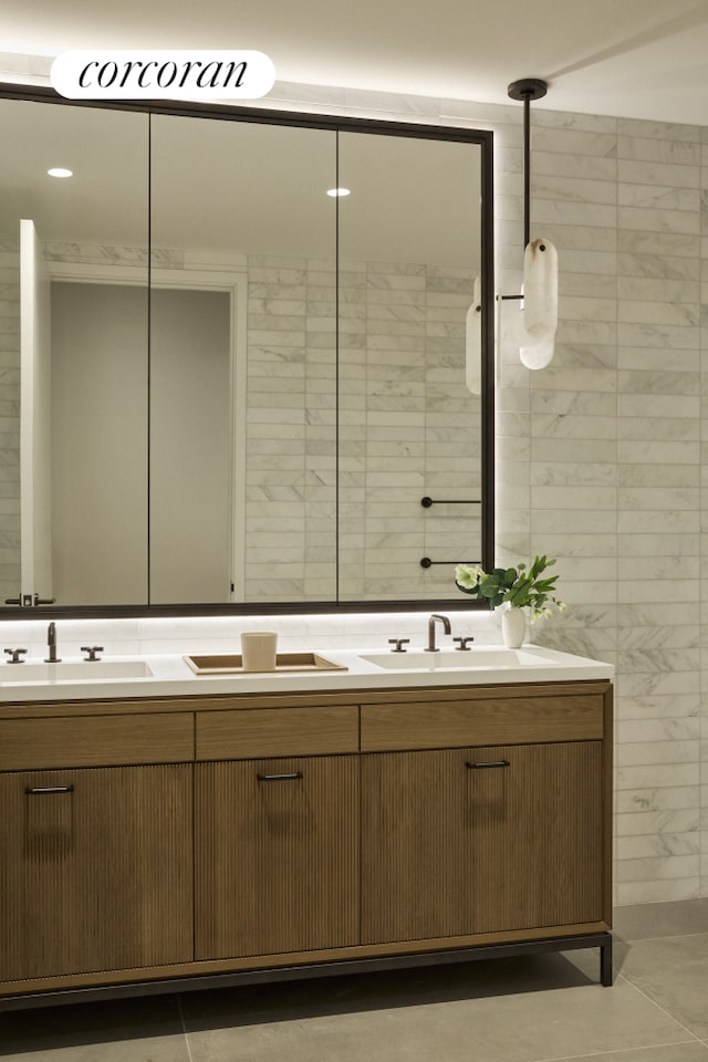 full bath featuring double vanity, tile patterned flooring, and a sink