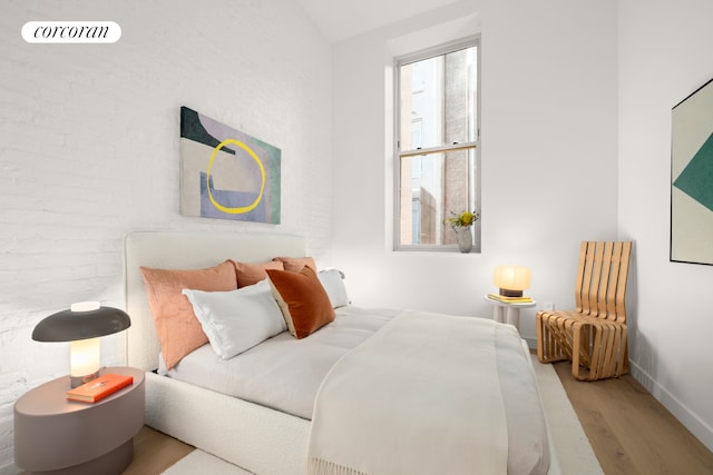 bedroom with wood finished floors, multiple windows, and baseboards