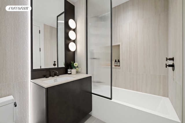 bathroom featuring vanity, shower / tub combination, toilet, and tile walls