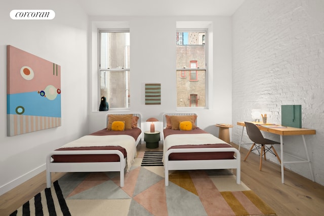 bedroom with wood finished floors, multiple windows, and baseboards