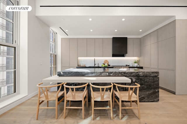 kitchen featuring a spacious island, gray cabinetry, decorative backsplash, modern cabinets, and light wood-type flooring