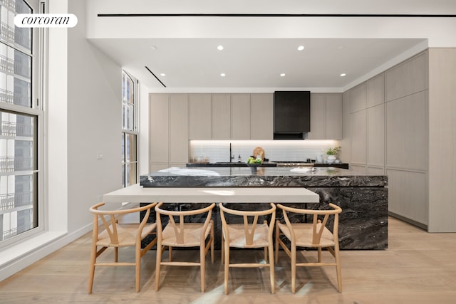 kitchen with gray cabinetry, light wood-style flooring, tasteful backsplash, modern cabinets, and a spacious island