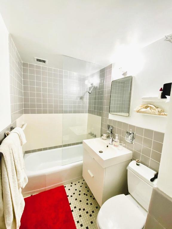 full bathroom with toilet, tiled shower / bath combo, tile walls, tile patterned floors, and vanity