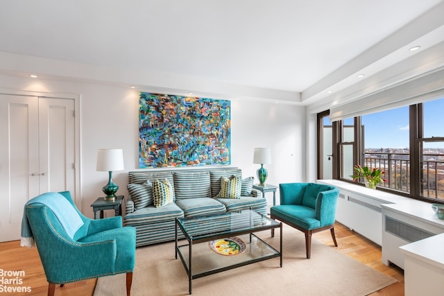 living area featuring light wood finished floors, radiator heating unit, and recessed lighting