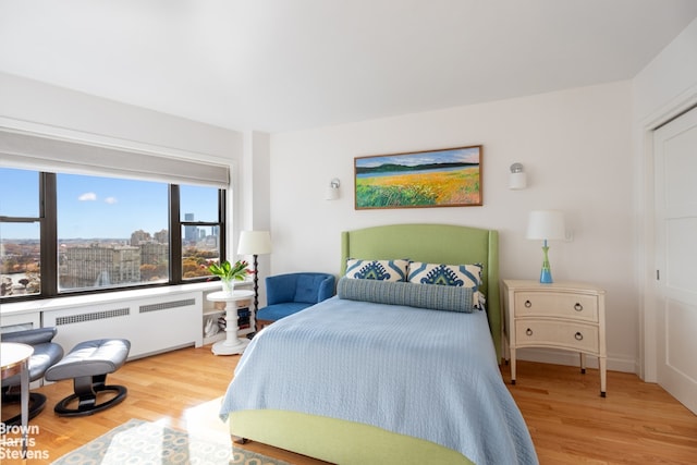 bedroom featuring radiator heating unit and wood finished floors