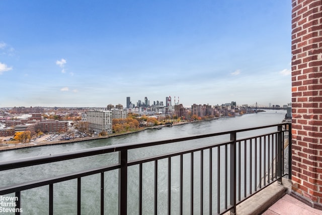 balcony with a water view and a view of city