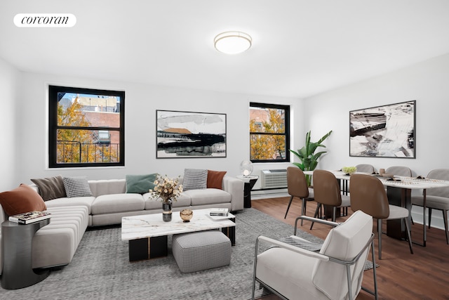 living area with visible vents, a wall unit AC, and wood finished floors