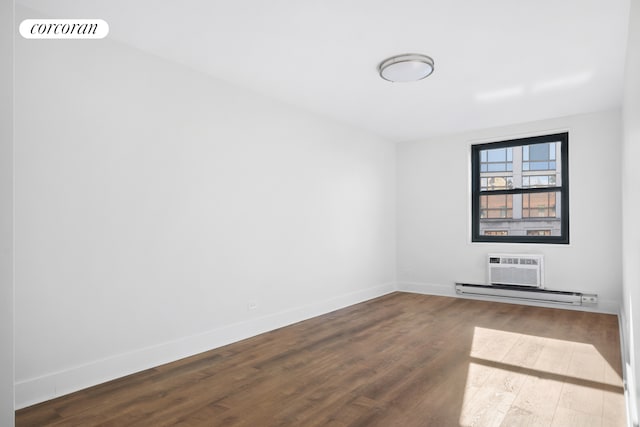 unfurnished room with dark wood-style floors, a wall mounted AC, a baseboard radiator, and baseboards