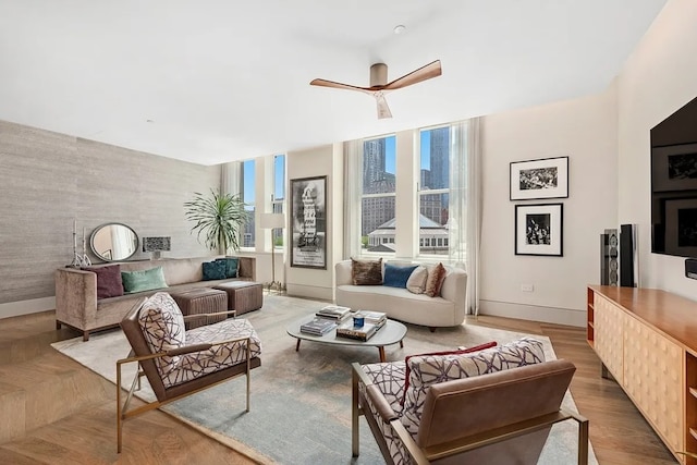 living room with ceiling fan and light hardwood / wood-style flooring