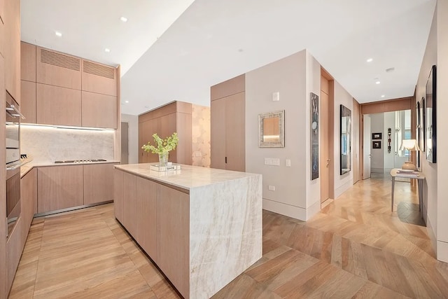 kitchen featuring a center island, light brown cabinetry, and modern cabinets