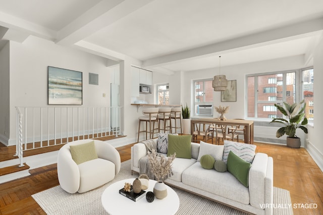 living room with a healthy amount of sunlight, radiator heating unit, light parquet flooring, and beamed ceiling