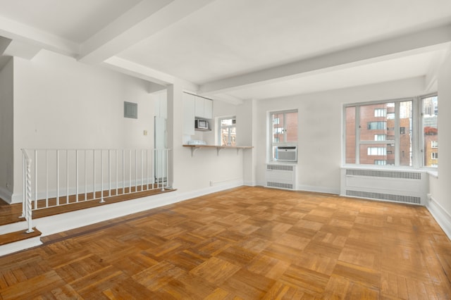 unfurnished living room featuring beam ceiling, radiator heating unit, and light parquet floors