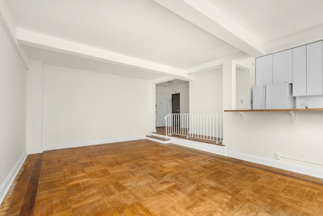 empty room featuring parquet flooring and beam ceiling