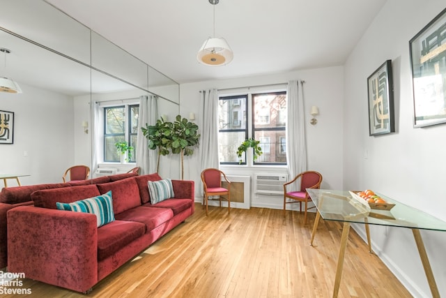 405 E 82nd St Unit 2H, New York City, NY 10028 - living area with light wood-style floors, a wall unit AC, and baseboards