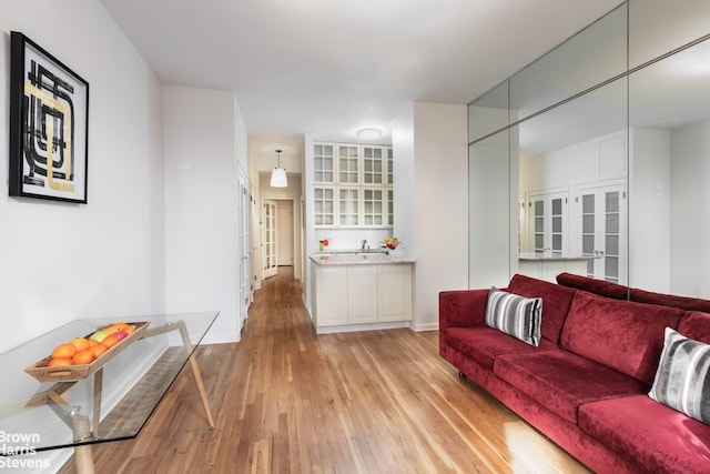 405 E 82nd St Unit 2H, New York City, NY 10028 - living room featuring light wood-type flooring, french doors, and baseboards