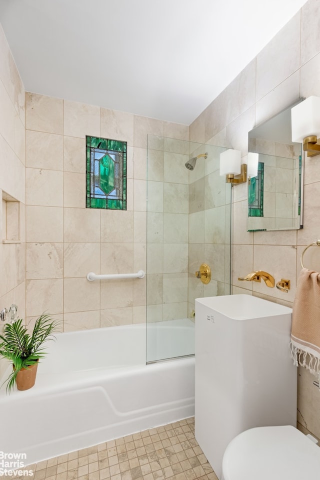 405 E 82nd St Unit 2H, New York City, NY 10028 - full bath featuring tile walls, toilet, shower / tub combination, a sink, and tile patterned floors