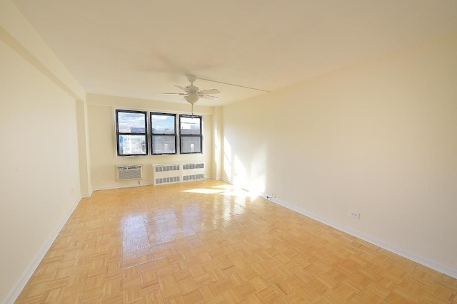 spare room featuring ceiling fan, radiator heating unit, and light parquet floors