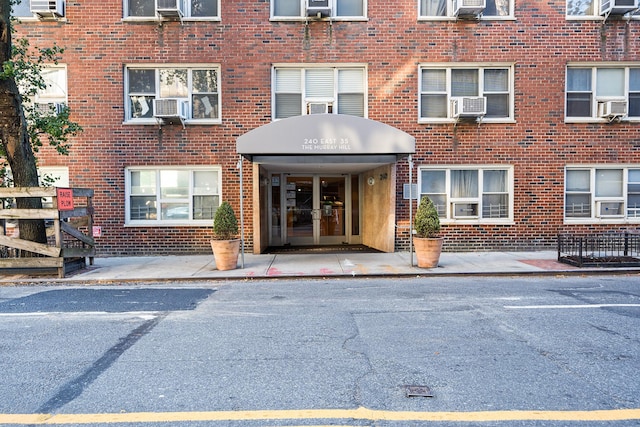 view of exterior entry featuring brick siding and cooling unit