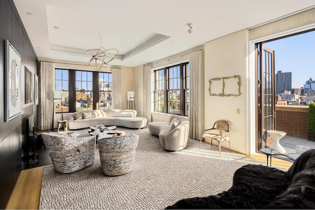 interior space featuring a raised ceiling and a notable chandelier