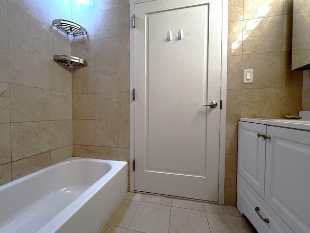 bathroom featuring tile patterned floors, vanity, tiled shower / bath combo, and tile walls