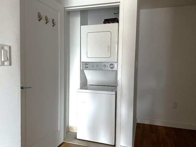 laundry room with stacked washer / drying machine and hardwood / wood-style floors