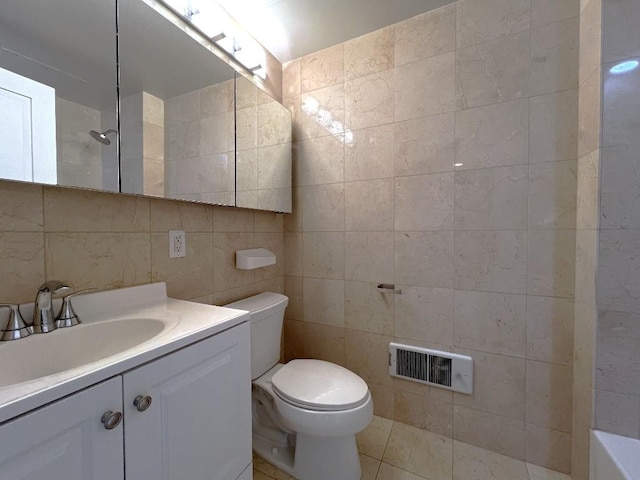 bathroom featuring vanity, toilet, tile walls, and a shower