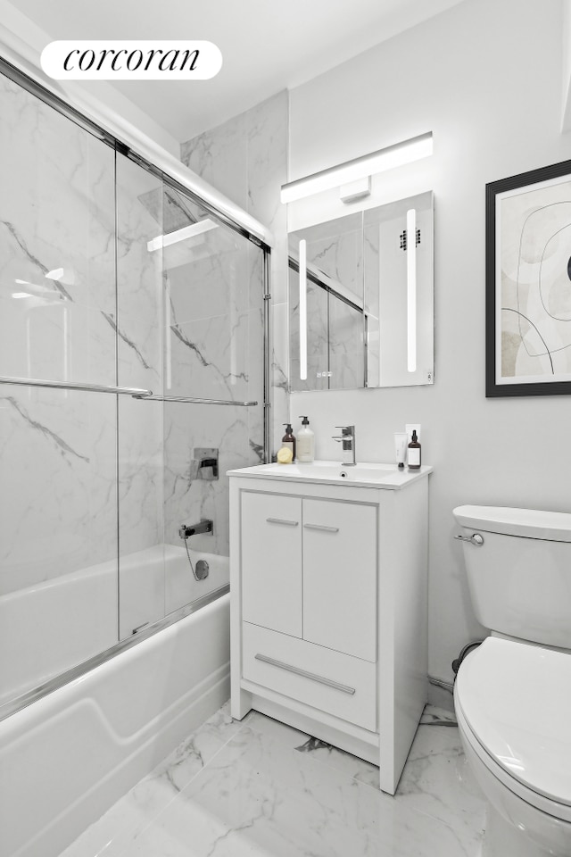 bathroom featuring toilet, marble finish floor, enclosed tub / shower combo, and vanity