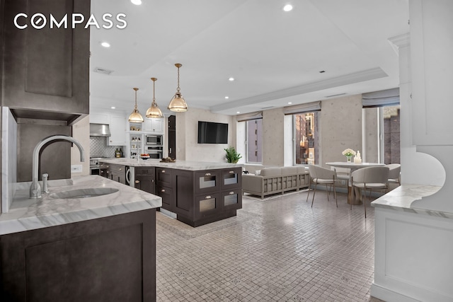 kitchen featuring under cabinet range hood, a sink, recessed lighting, stainless steel appliances, and dark brown cabinetry