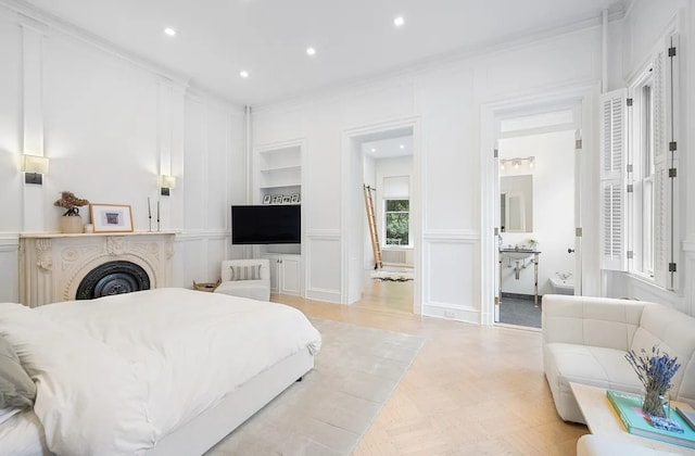 bedroom with ensuite bath and ornamental molding