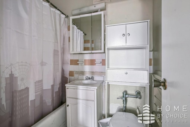 full bathroom with tile walls, backsplash, vanity, shower / tub combo, and toilet