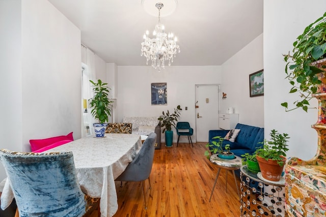 dining space with hardwood / wood-style flooring and a notable chandelier