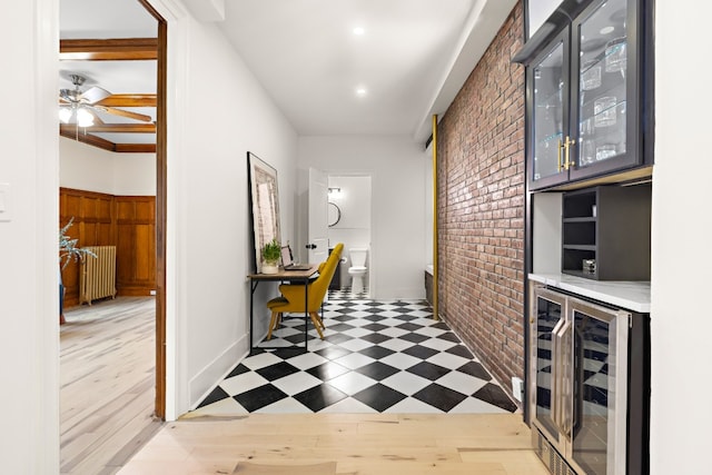 hall with brick wall, radiator, and wine cooler