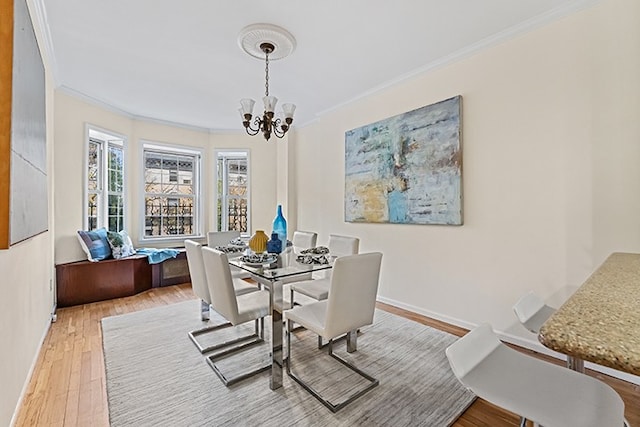 dining room with light wood-type flooring, a notable chandelier, and crown molding